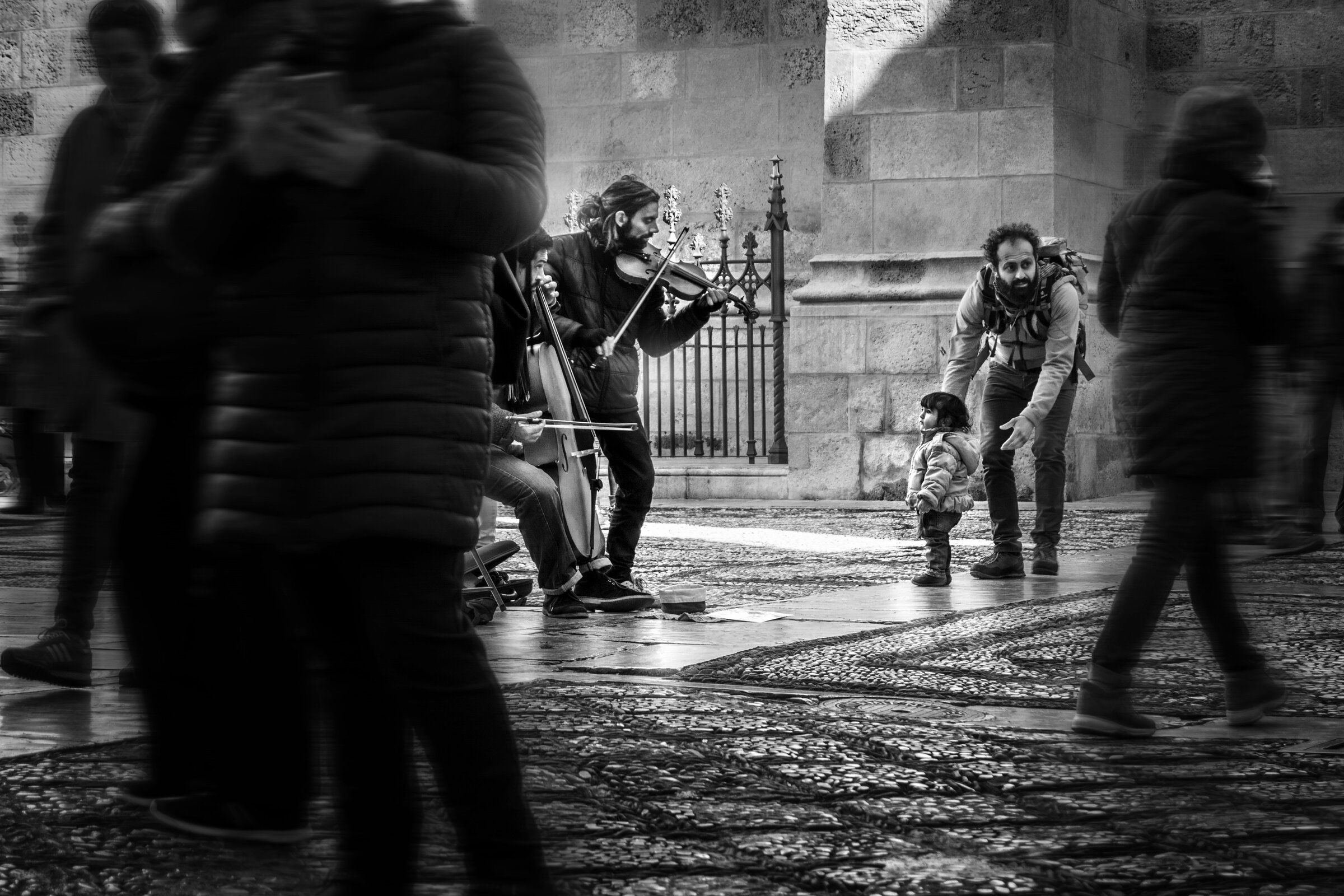 Personas escuchan a unos músicos en la calle